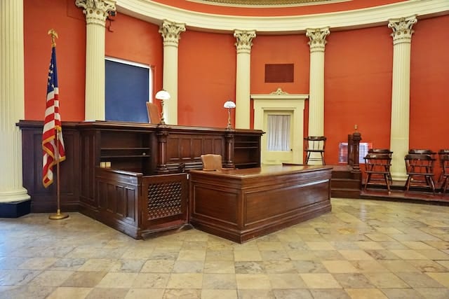 Inside a court room showing United States flag on pole
