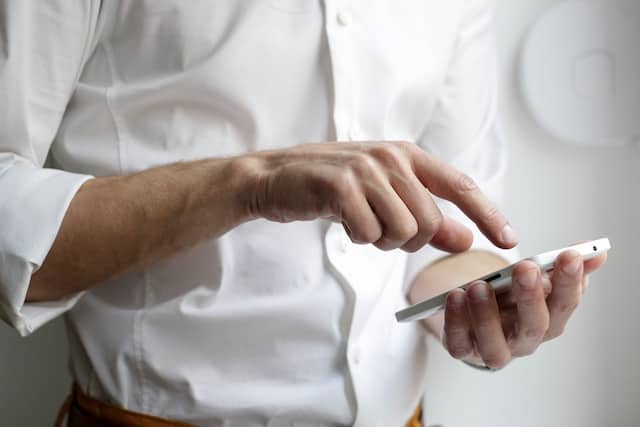 Person hand holding a smart phone and dialing number